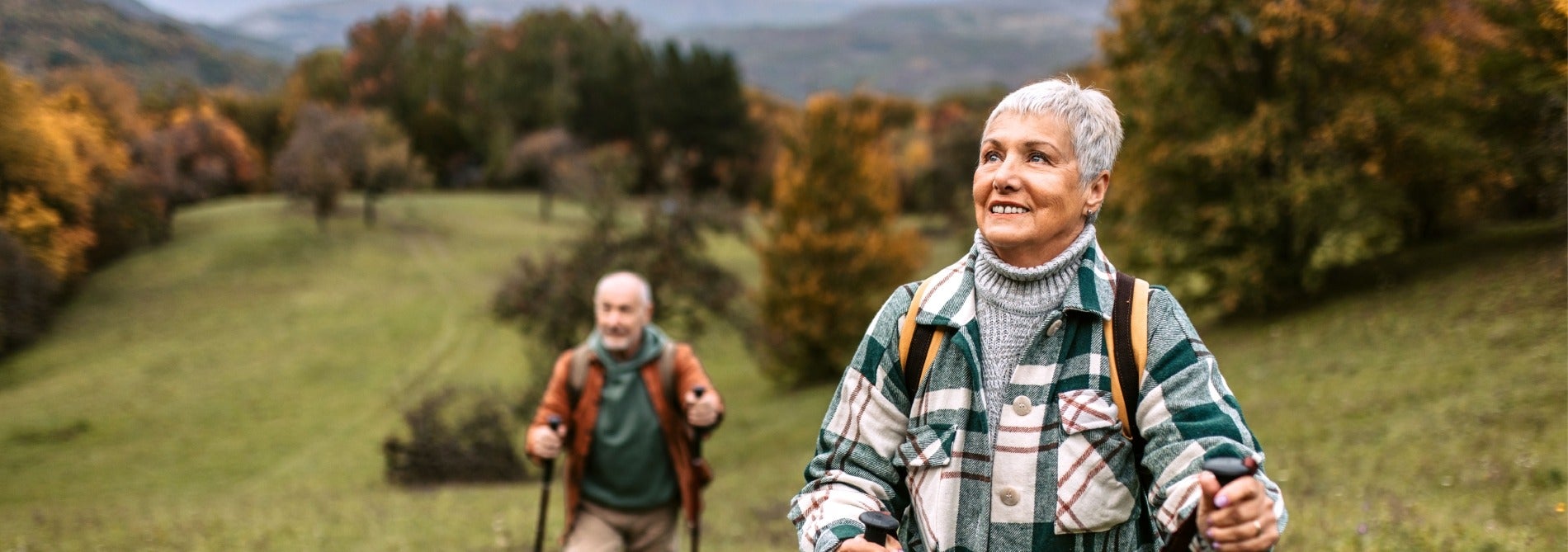 Older couple hiking up hill