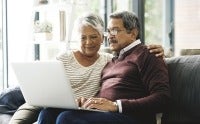 Mature couple reviewing information on a computer screen together