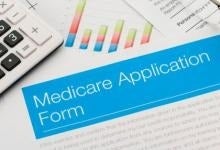 Photo of calculator and Medicare Application Form 