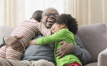 Grandfather hugging his young grandchildren