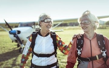 Two senior friends smiling after a successful skydive