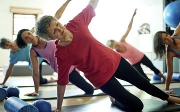  Active senior woman stretching in a yoga class