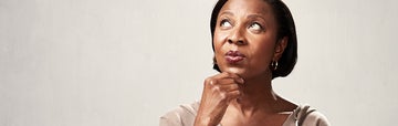 Woman pondering with her hand on her chin