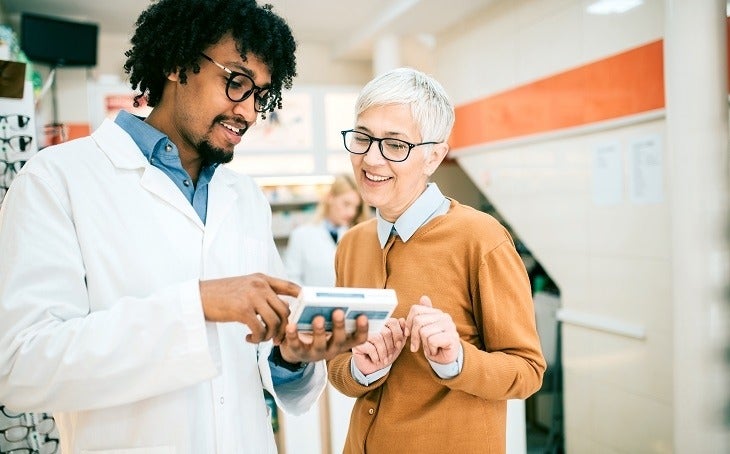 Pharmacist educating customer about her new medication