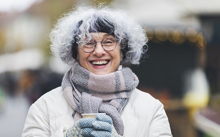 Senior woman enjoying a warm drink on a cold day 