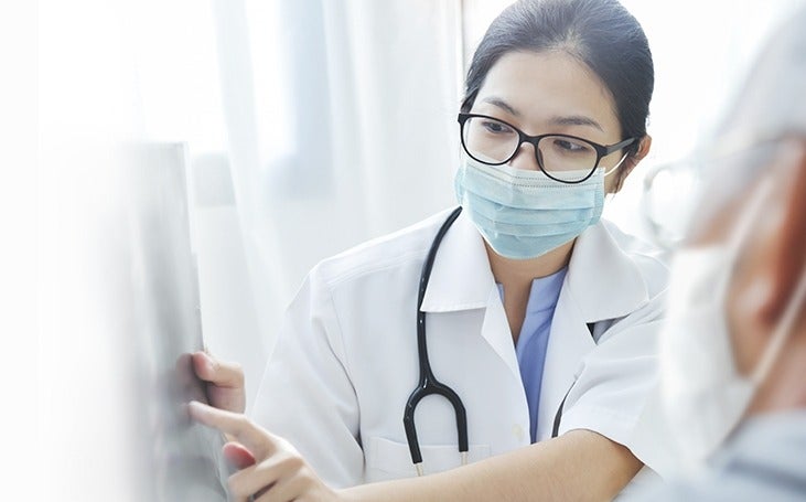 Doctor reviewing x-ray with elderly patient