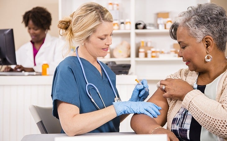 Nurse gives vaccine to senior adult patient 