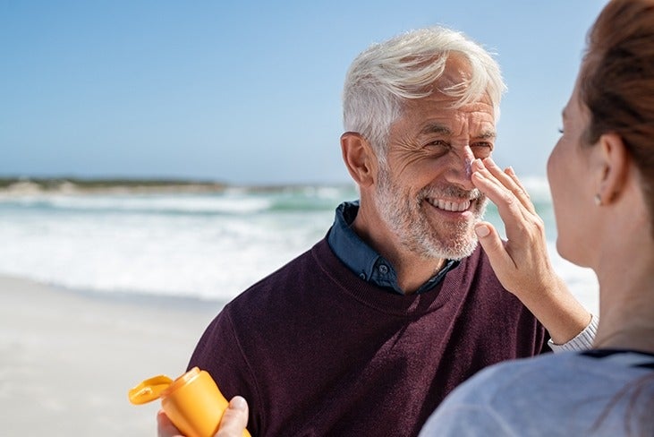 Man applies sunscreen on the beach